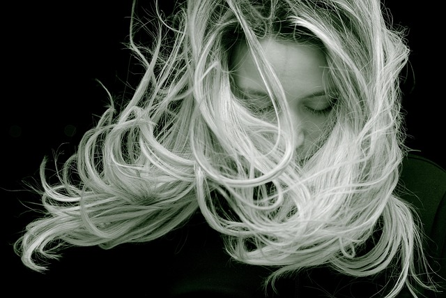 A woman looking down against a dark background