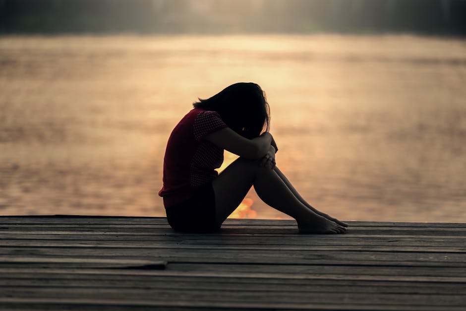 A person sitting quietly beside the water